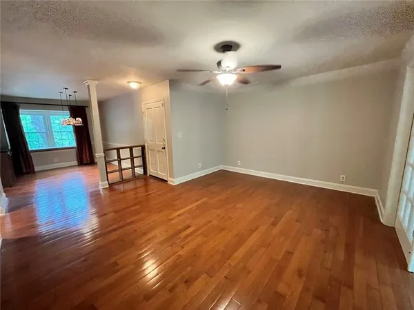 a view of empty room with wooden floor