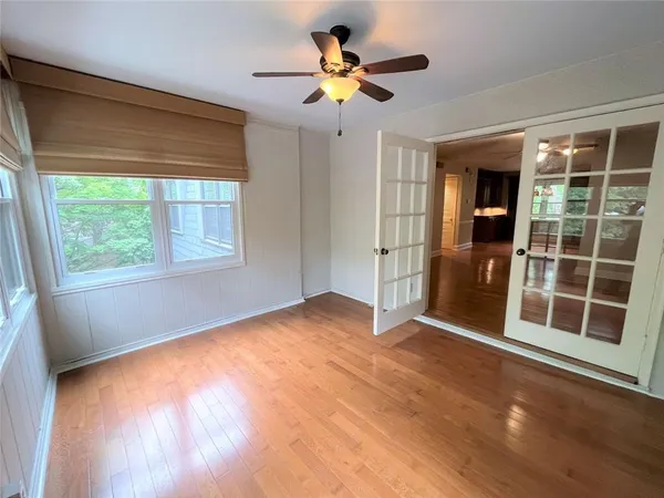a view of an empty room with a window and wooden floor