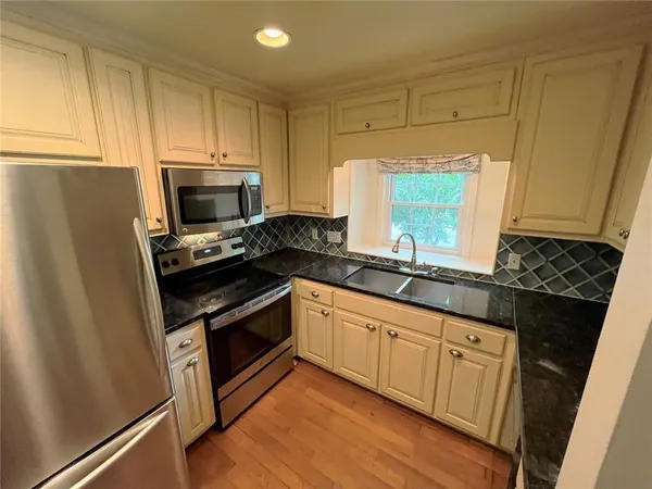 a kitchen with granite countertop a sink and a stove top oven