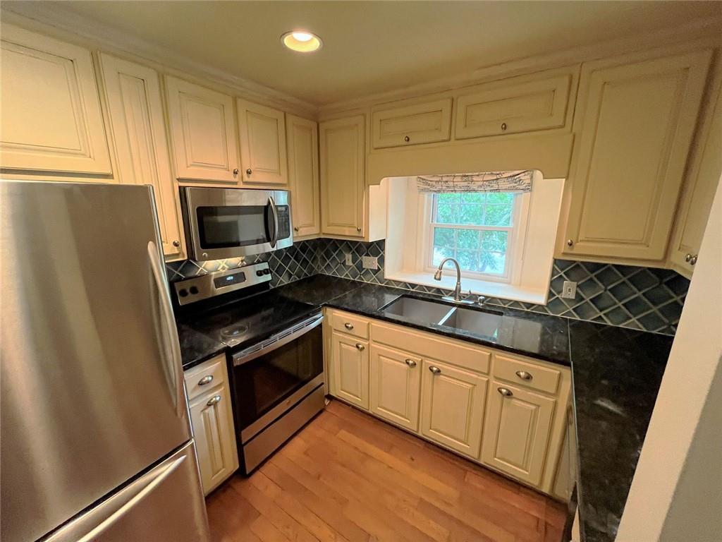 82 Montre Square Northwest Atlanta, GA 30327 - Photo 18 of 44 a kitchen with granite countertop a sink and a stove top oven