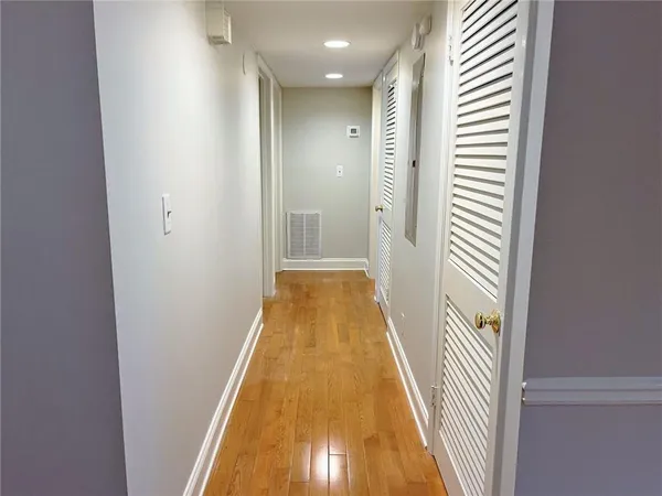 a view of a hallway with wooden floor and closet