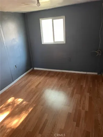a room with a wooden floor and white wall