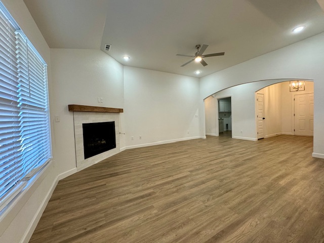 2250 Hunter Drive Pea Ridge, AR 72751 - Photo 4 of 21 Spacious room with wood-finish flooring, a fireplace featuring a wood mantel, and arched doorways