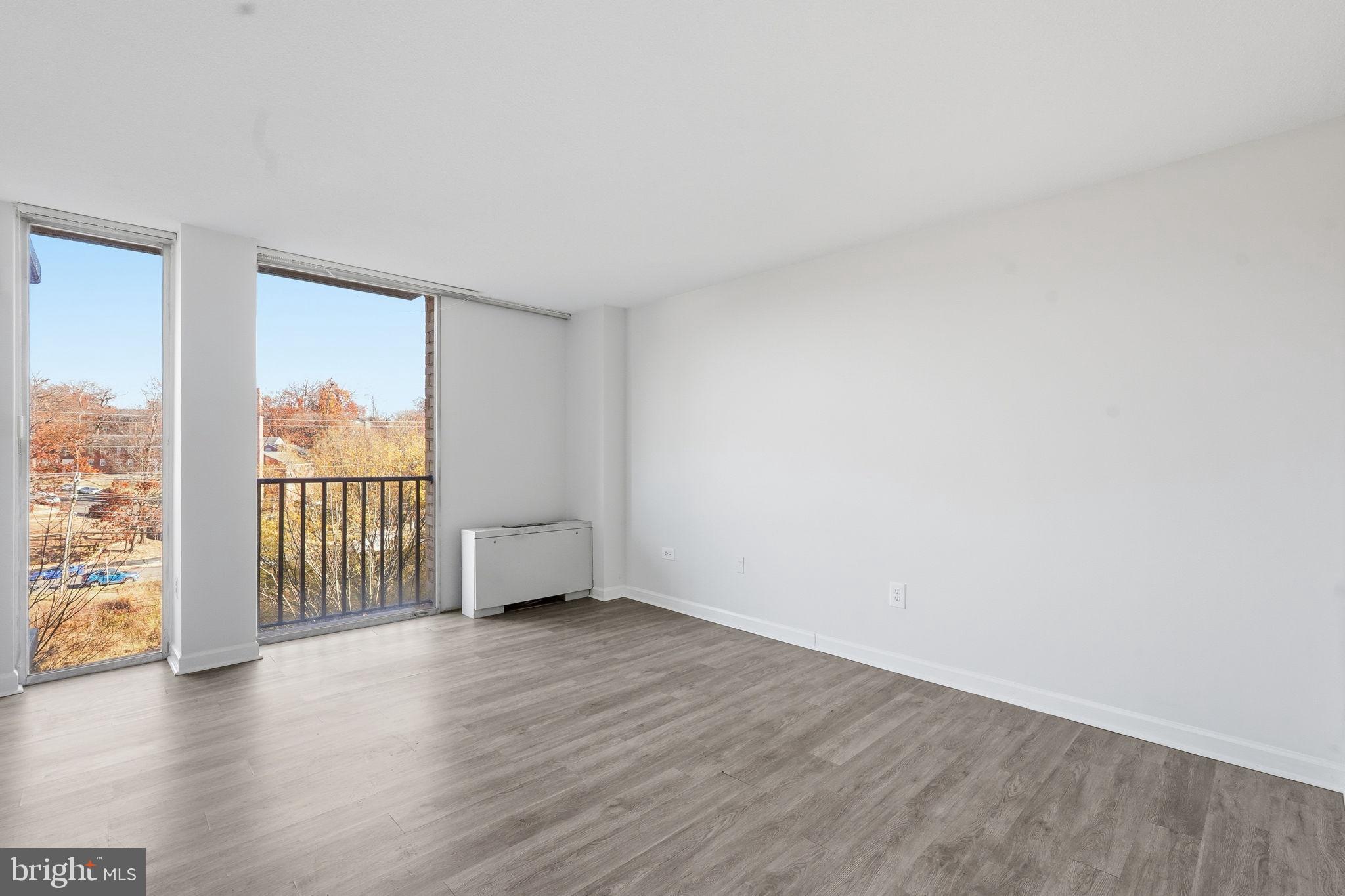 4600 South Four Mile Run Drive, Unit 613 Arlington, VA 22204 - Photo 15 of 24 a view of an empty room with wooden floor and a window