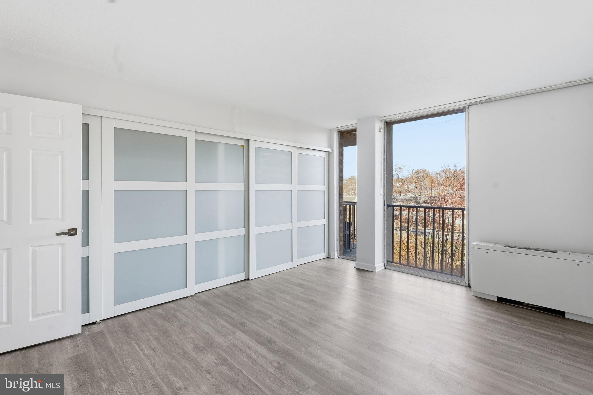 4600 South Four Mile Run Drive, Unit 613 Arlington, VA 22204 - Photo 17 of 24 a view of an empty room with a window and wooden floor
