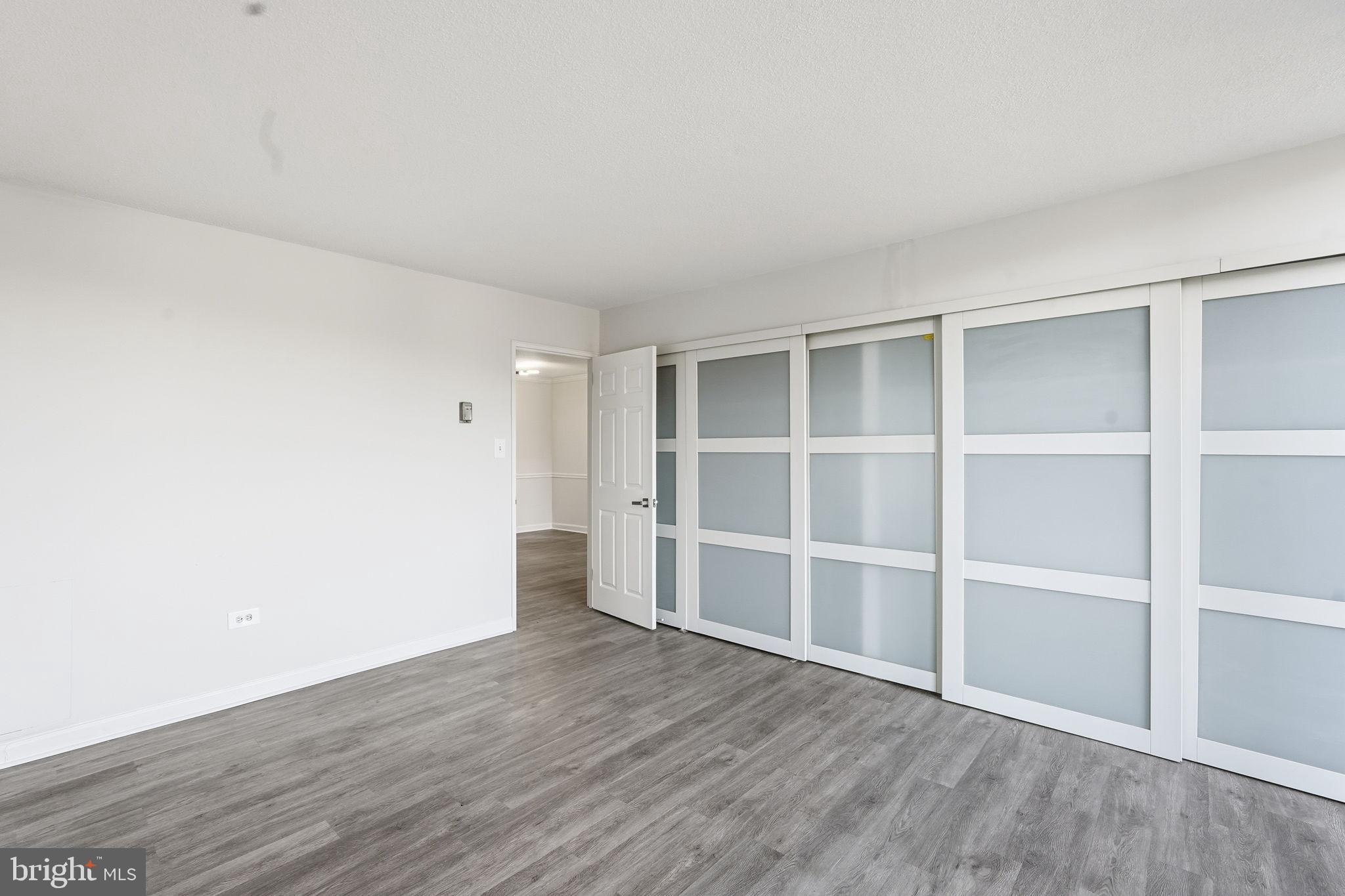 4600 South Four Mile Run Drive, Unit 613 Arlington, VA 22204 - Photo 18 of 24 a view of an empty room with wooden floor and closet