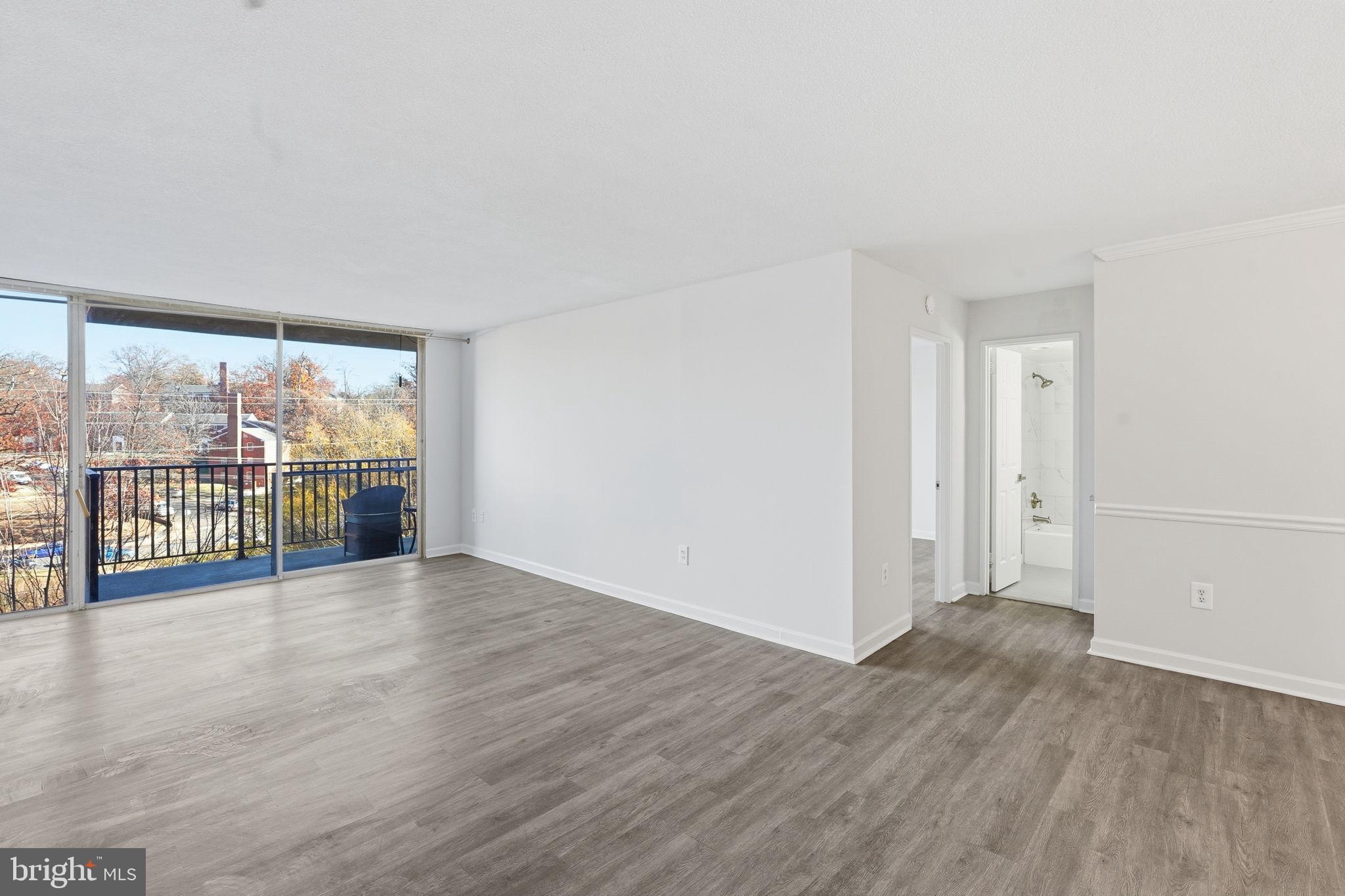 4600 South Four Mile Run Drive, Unit 613 Arlington, VA 22204 - Photo 7 of 24 a view of an empty room with wooden floor and a window