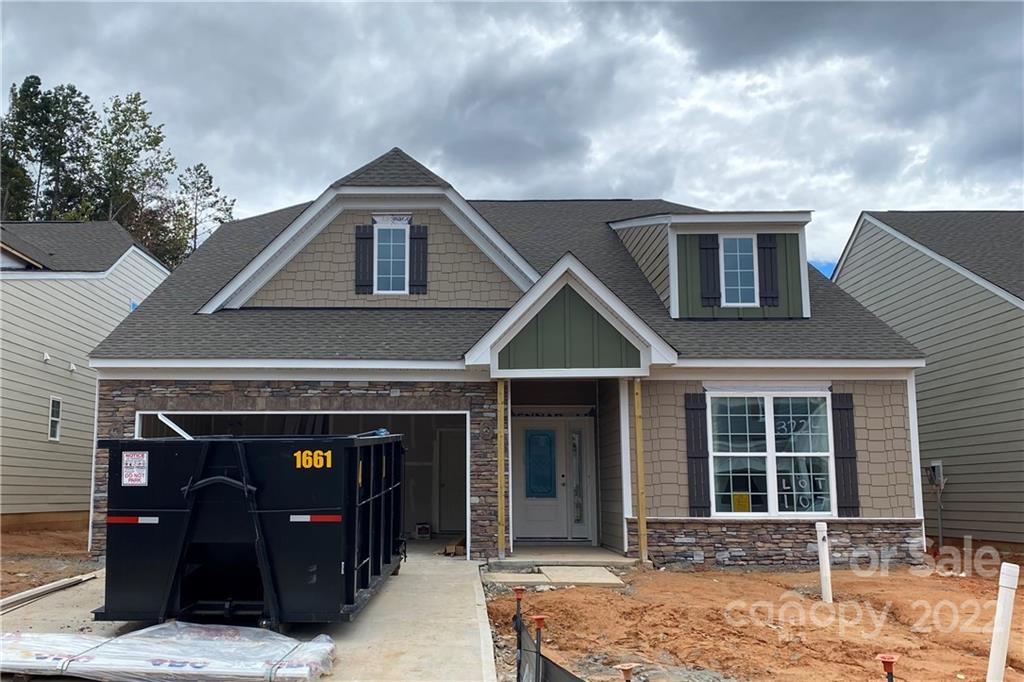 a front view of a house with yard and parking