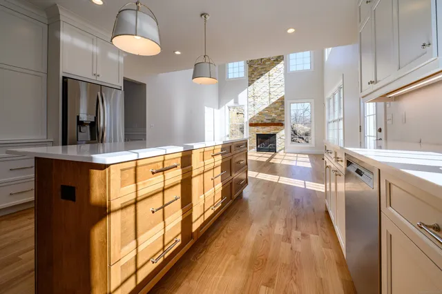 a view of a kitchen with kitchen island wooden floor center island and stainless steel appliances
