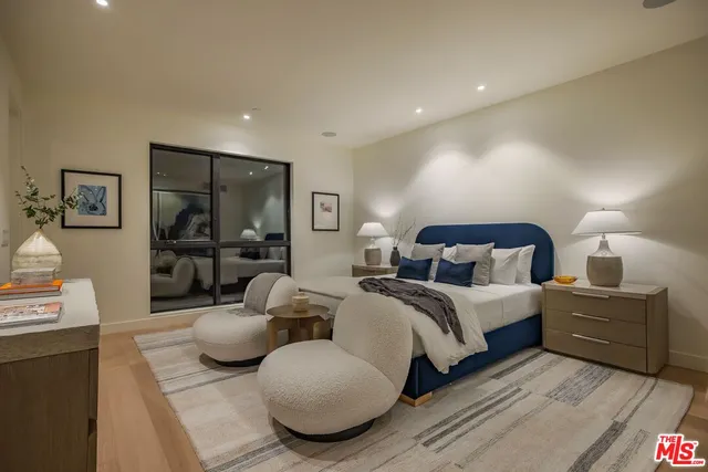 a spacious bedroom with two beds and a large mirror