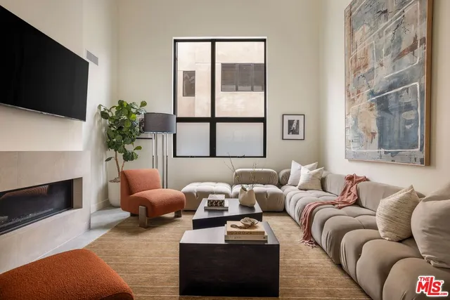 a living room with furniture a flat screen tv and a fireplace
