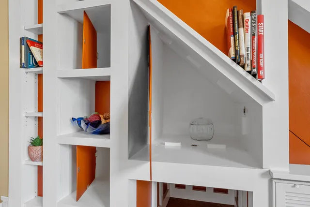 a living room with furniture a large window and wooden floor