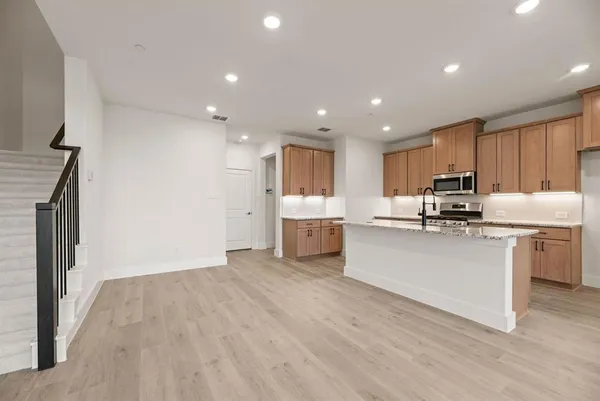 a kitchen with stainless steel appliances granite countertop a refrigerator sink and white cabinets