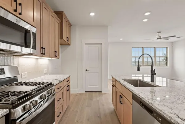 a kitchen with stainless steel appliances granite countertop a stove and a sink