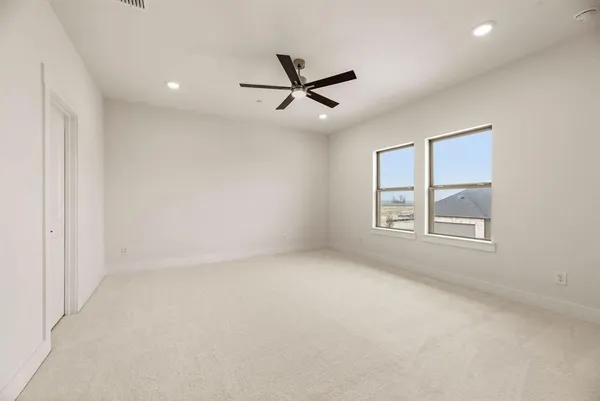 an empty room with windows and fan