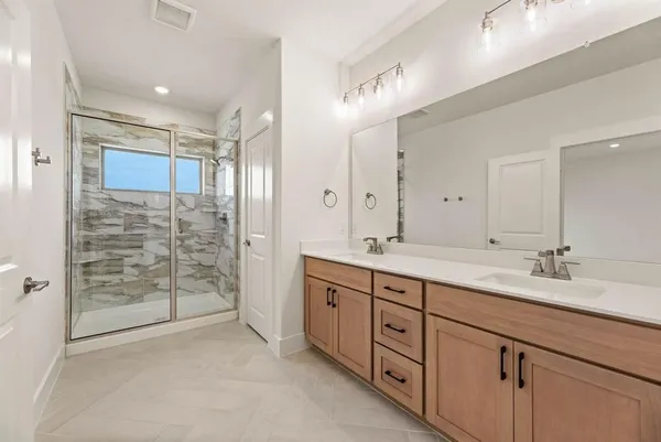 a spacious bathroom with double sink and shower