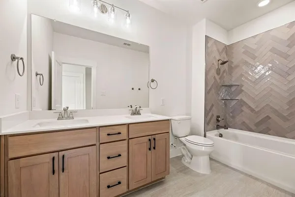 a bathroom with a granite countertop sink toilet a large mirror a bathtub and shower