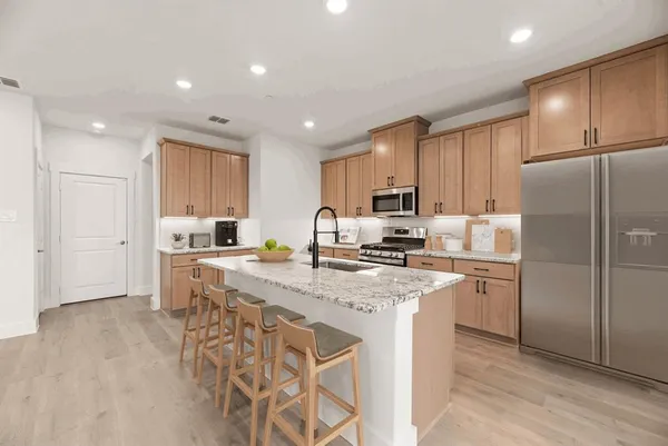 a kitchen with a refrigerator a sink and cabinets