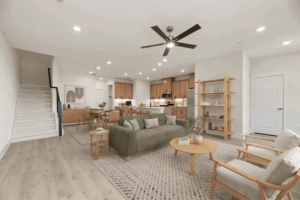 a living room with furniture and a view of kitchen