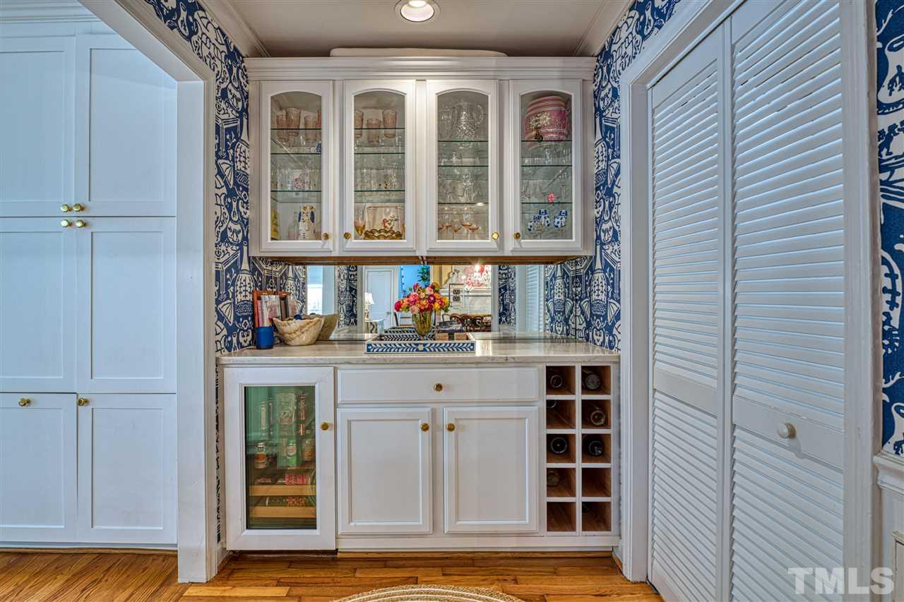 2705 Cooleemee Drive Raleigh, NC 27608 - Photo 9 of 30 Clarence House wallpaper, wine refrigerator, and convenient location between the kitchen and formal dining room make this space stand out!