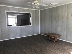 1414 Woodward Street Damon, TX 77430 - Photo 2 of 5 a view of a livingroom with a fan and wooden floor