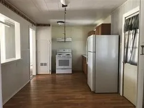 a kitchen with stainless steel appliances a refrigerator and wooden floor