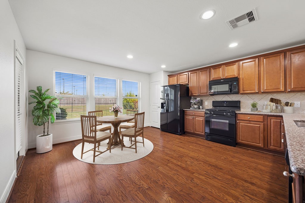 342 Ranch House Lane Richmond, TX 77469 - Photo 5 of 17 a kitchen with a table chairs refrigerator and microwave