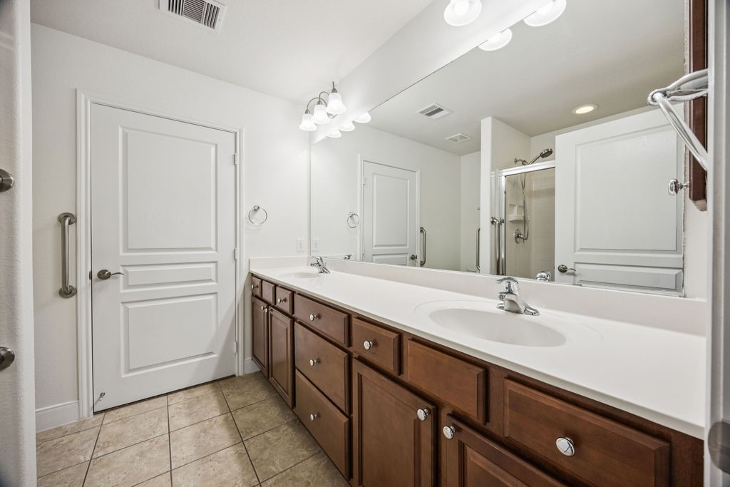 342 Ranch House Lane Richmond, TX 77469 - Photo 9 of 17 a bathroom with a double vanity sink a mirror and a bathtub