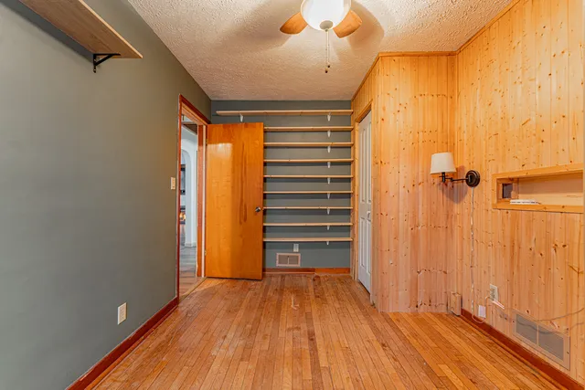 a view of a room with wooden floor and door