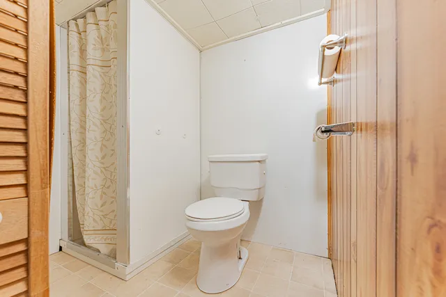 a bathroom with a toilet and a shower