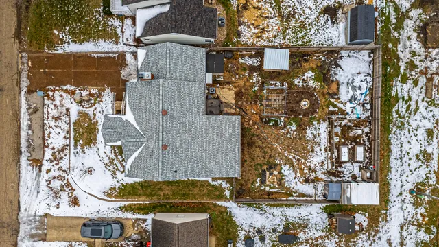aerial view of a house with a yard and large trees