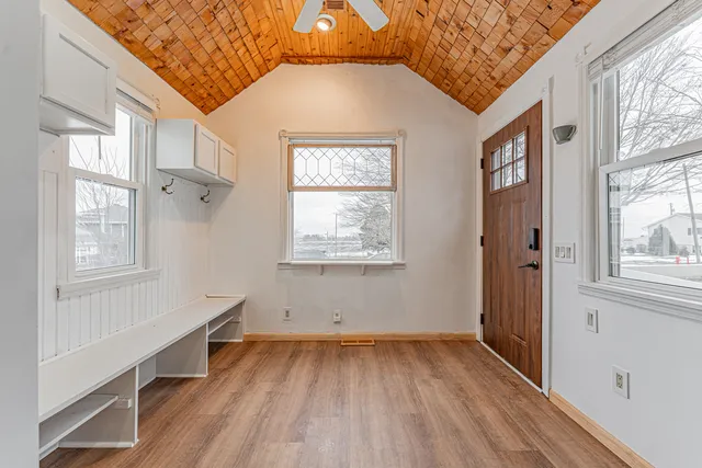 an empty room with wooden floor and windows