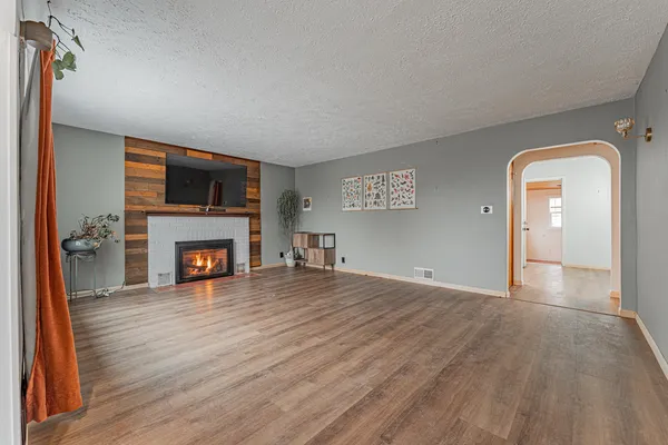 a view of an empty room with a fireplace and a window