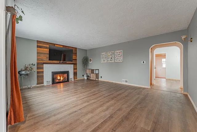 a view of an empty room with a fireplace and a window