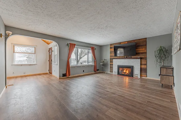 wooden floor fireplace and windows in an empty room