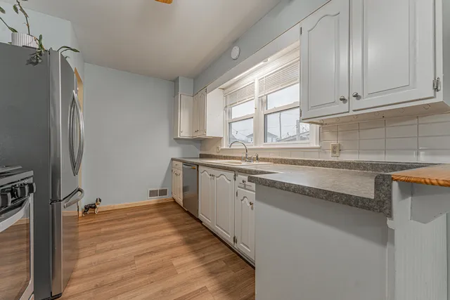 a kitchen with granite countertop a sink stainless steel appliances and cabinets
