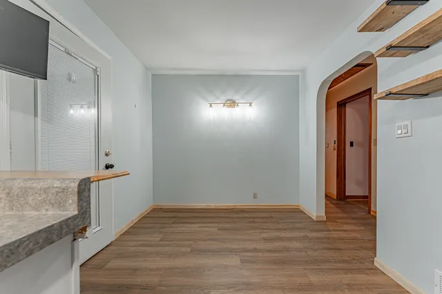 a view of a hallway with wooden floor and staircase