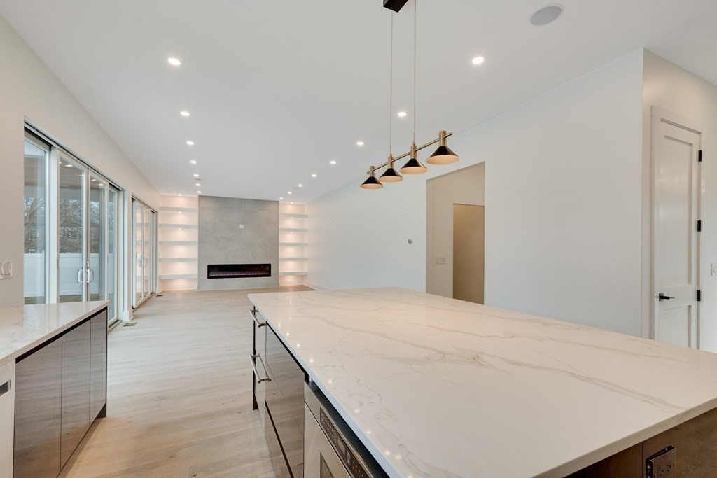 9 Richard Road Needham, MA 02492 - Photo 2 of 31 a large white room with kitchen view and wooden floor