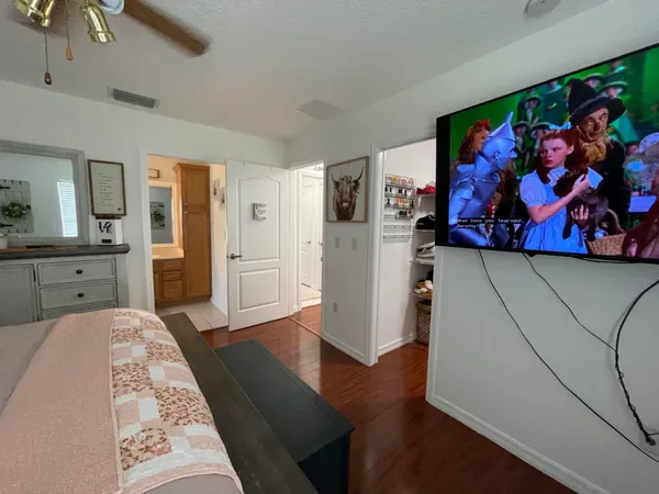 a spacious bedroom with a bed and a painting on the wall