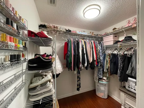 a view of walk in closet with clothes and shoes
