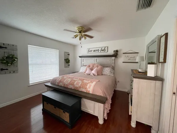a bedroom with a bed wooden floor and window