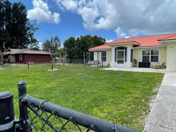 a view of a house with backyard sitting area and garden