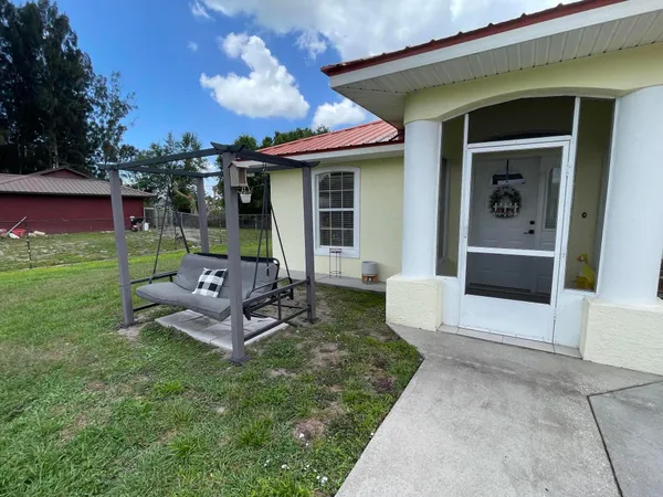a view of a house with backyard sitting area and garden