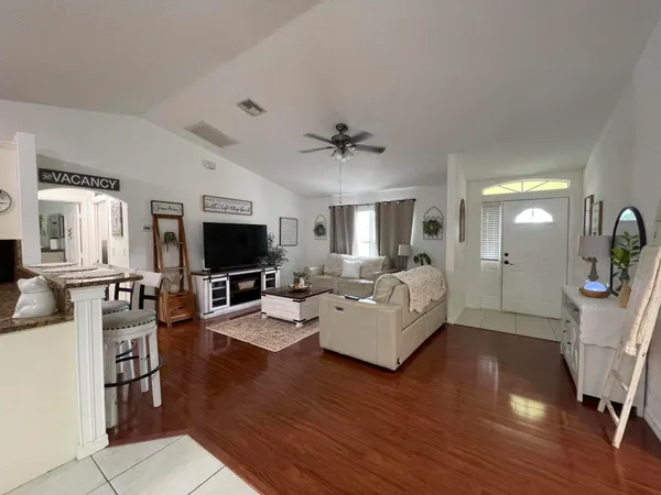 a living room with furniture flat screen tv and wooden floor