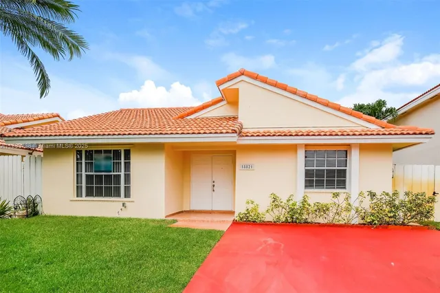 a front view of a house with a yard and potted plants