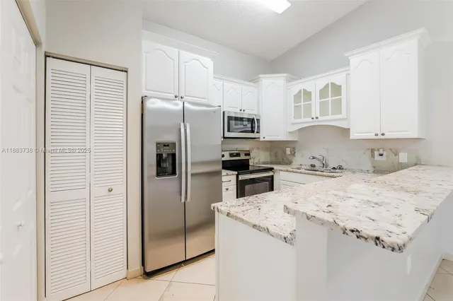 a kitchen with stainless steel appliances granite countertop a stove microwave and cabinets
