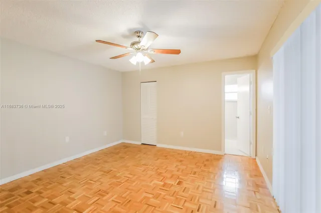 a view of an empty room with closet and wooden floor