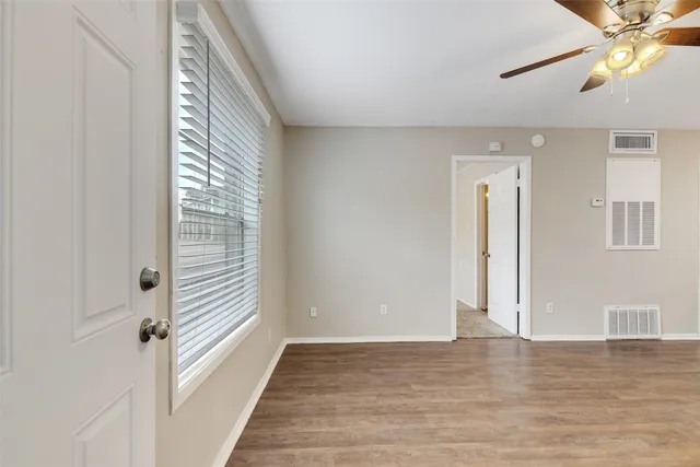 a view of a room with wooden floor and window