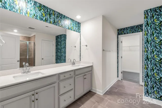 a spacious bathroom with a double vanity sink and mirror