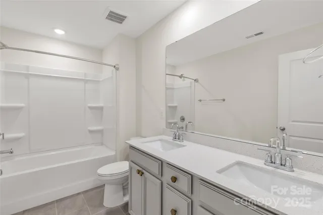 a bathroom with a granite countertop sink a toilet and shower